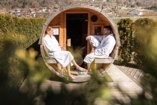a man and a woman sitting in a bath tub at Hotel Nele in Ziano di Fiemme