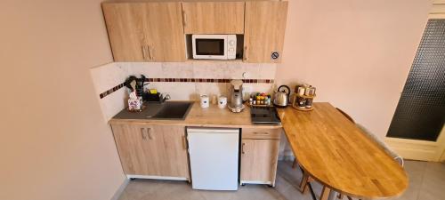 a small kitchen with a table and a microwave at Luxe-Home in Châtenoy-le-Royal