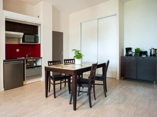 a kitchen and dining room with a table and chairs at Vacancéole - Le Duguesclin in Dinan