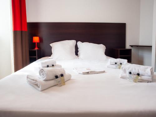 a bedroom with a bed with towels on it at Vacancéole - Le Duguesclin in Dinan