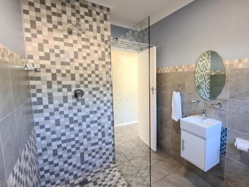 a bathroom with a sink and a shower with a mirror at The Nathaniel in Blue Bend