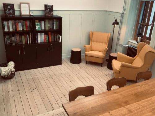 a living room with two chairs and a book shelf at Culinarium Alpinum in Stans
