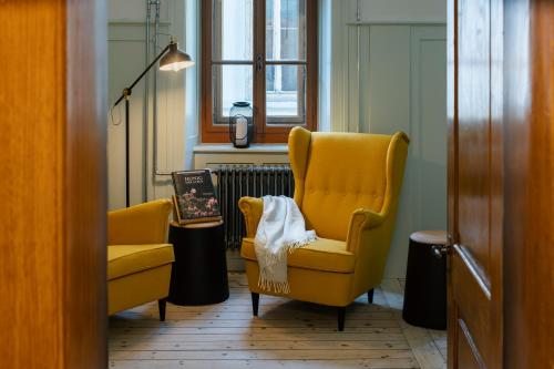 a room with two yellow chairs and a radiator at Culinarium Alpinum in Stans