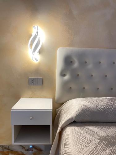 a bedroom with a bed and a nightstand and a lamp at Narcisse in Tropea