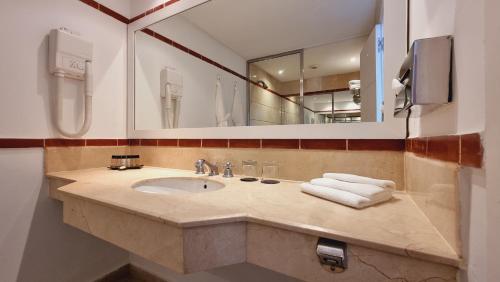 a bathroom with a sink and a mirror and towels at Marina Smir Hotel & Spa in M'diq