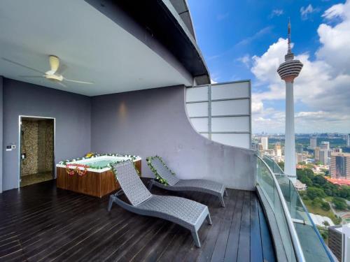 a balcony with two chairs and a bed on top of a building at The Luxury Penthouse Twin Tower view in Kuala Lumpur