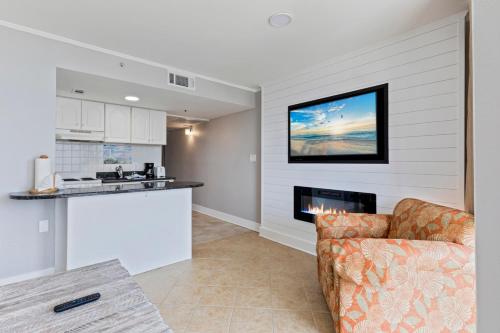 eine Küche und ein Wohnzimmer mit einem Sofa und einem Kamin in der Unterkunft Hosteeva 1-bedroom Meridian Plaza Condo with Ocean View in Myrtle Beach