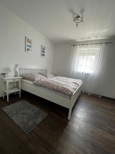 Schlafzimmer mit einem Bett, einem Tisch und einem Fenster in der Unterkunft Ferienwohnung Sonnengarten in Schönberg
