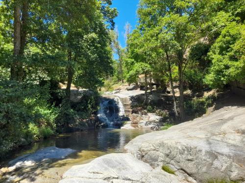 una cascada en un río con rocas y árboles en La casa del puerto, en El Arenal