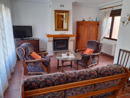 a living room with a couch and chairs and a fireplace at La casa del puerto in El Arenal