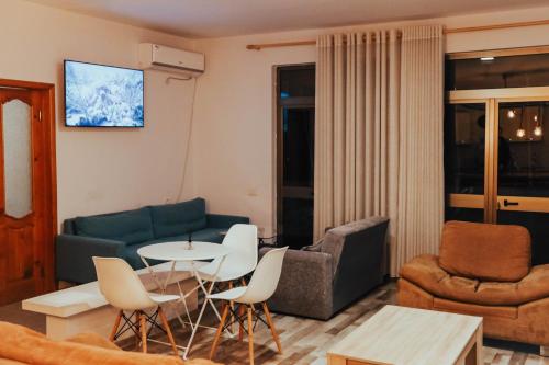 a living room with a couch and a table and chairs at ART Hostel in Tirana