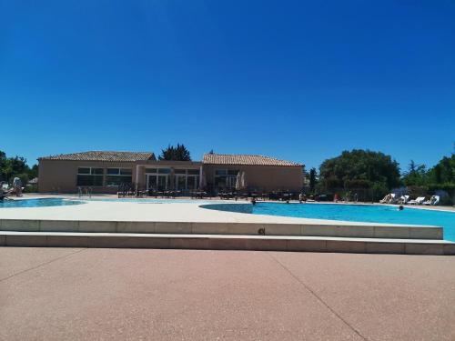 a swimming pool with a building in the background at BASTIDON EN PROVENCE in Aubignan