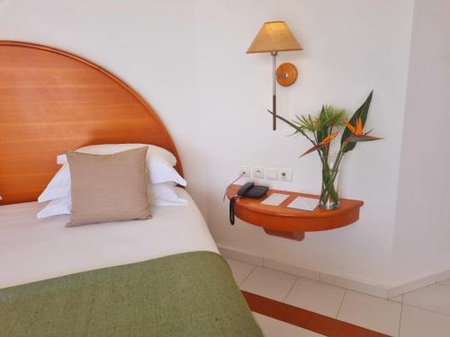 a bedroom with a bed and a table with a plant at Marina Smir Hotel & Spa in M'diq
