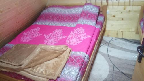 a small bed with a pink blanket on it at Zaovinski Raj2 Tara in Konjska Reka