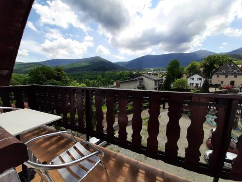 a balcony with a table and chairs and mountains at Usługi hotelarskie Karpacz in Karpacz