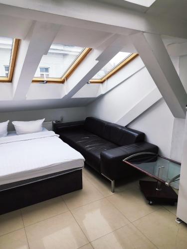 a bedroom with a black couch and a glass table at Hoża Apartments and Rooms in Warsaw