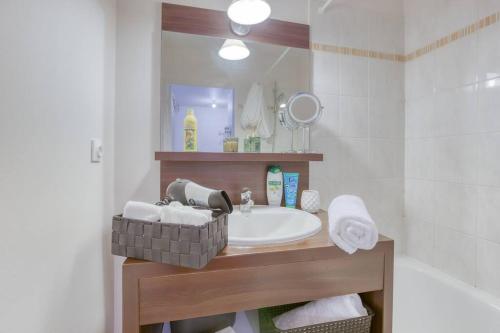 une salle de bain avec un lavabo et un miroir dans l'établissement Magnifique 5 min de Disney parking privée, à Montévrain
