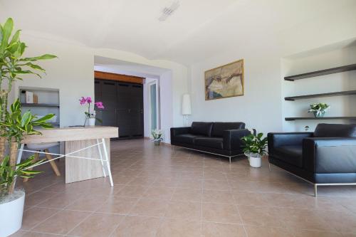 a living room with two black couches and a table at Sogno in Langa in Monforte dʼAlba