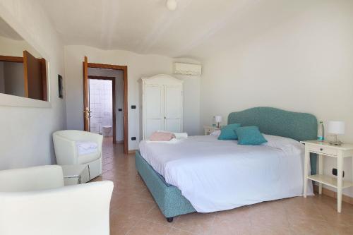 a bedroom with a white bed and a blue chair at Sogno in Langa in Monforte dʼAlba