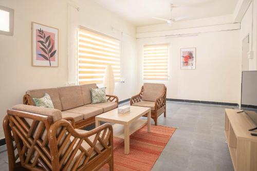 a living room with a couch and chairs at Neemtree Apartments in Hyderabad