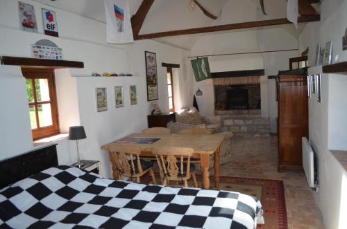 un salon avec une table et une cheminée dans l'établissement Lake View Cottage close to Le Mans 24H circuit, à Louplande