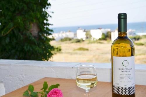 a bottle of wine and a glass on a table at Aristea Apartment in Milatos