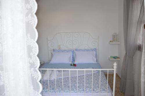 a white crib with a white headboard in a bedroom at Aristea Apartment in Milatos