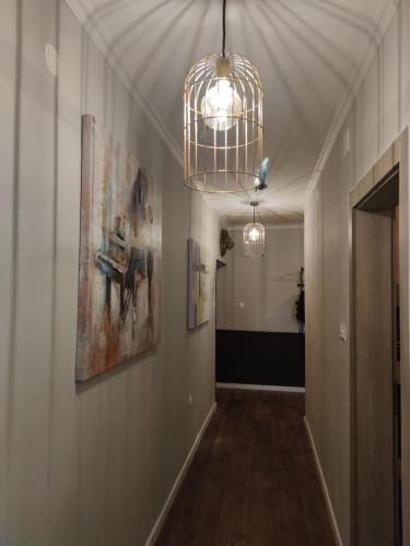 a hallway with paintings on the wall and a chandelier at Apartments Sabo in Kraljevica