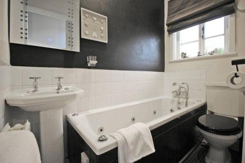 uma casa de banho com um lavatório, uma banheira e um WC. em In the Heart of Chester, Historical & Stylish em Chester