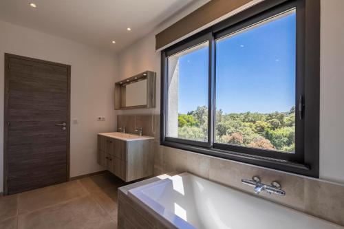 baño con lavabo y ventana grande en Villa 18, en Porto Vecchio