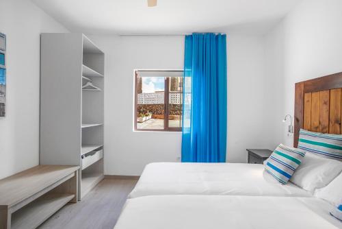 sypialnia z łóżkiem i niebieską zasłoną w obiekcie Casa Flora w mieście Villaverde