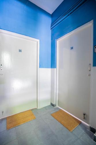 two white doors in a room with blue walls at Neemtree Apartments in Hyderabad