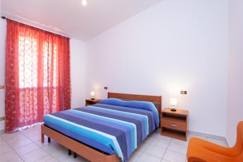een slaapkamer met een blauw bed en 2 nachtkastjes bij La Caletta casa per vacanze in La Caletta