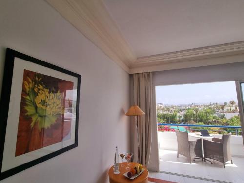 a living room with a table and a large window at Marina Smir Hotel & Spa in M'diq