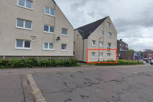 a building with an orange stripe on the side of it at Lovely 2 Bedroom Modern Ground Floor Flat in Clydebank