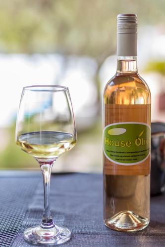 a bottle of white wine next to a glass at House Oliva with private pool and large garden in Stari Grad
