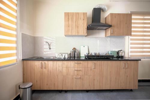 a kitchen with wooden cabinets and a black counter top at Neemtree Apartments in Hyderabad