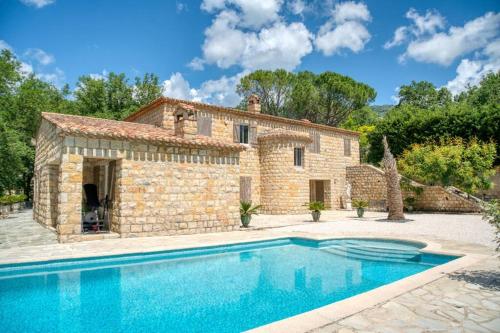 an external view of a stone house with a swimming pool at BASTIDE PROVENÇALE PROCHE CANNES in Peymeinade