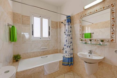 a bathroom with a sink and a bath tub and a toilet at Villa Semeli by Villa Plus in Peyia