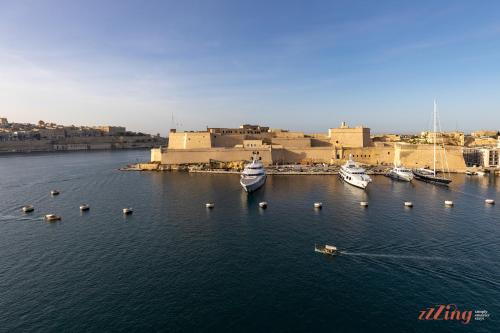 a group of boats in the water in front of a building at Stunning Holiday Home with Gorgeous Harbour Views in Senglea