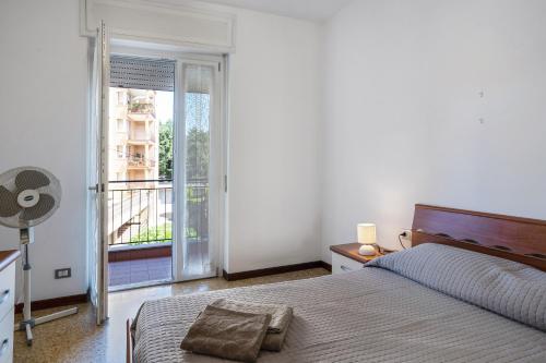 a white bedroom with a bed and a balcony at Iris Apartment Lago Maggiore in Angera