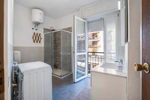 a bathroom with a sink and a glass door at Iris Apartment Lago Maggiore in Angera