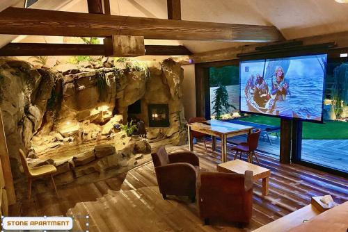 a dining room with a large screen in a rock wall at You and Me Apartments in Prosenická Lhota