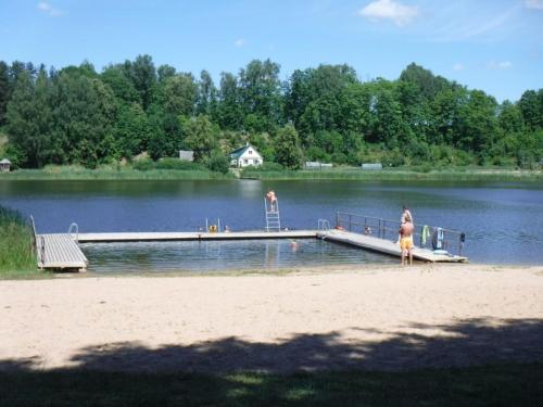 une femme debout sur un quai sur un lac dans l'établissement Harmonija, à Ludza