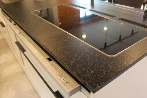 a kitchen counter with a black counter top at 佐世保VILLA青鹿Ur1 in Sasebo