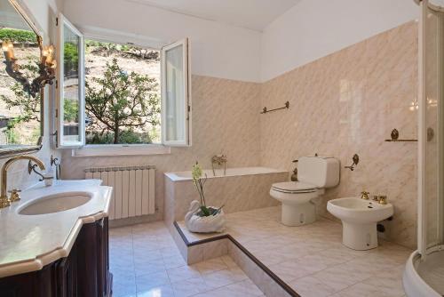 a bathroom with a tub and a toilet and a sink at Miriam e Carlo in Moneglia