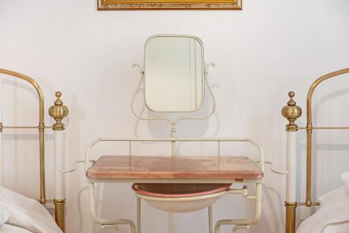 a dressing table with a mirror next to two beds at Miriam e Carlo in Moneglia