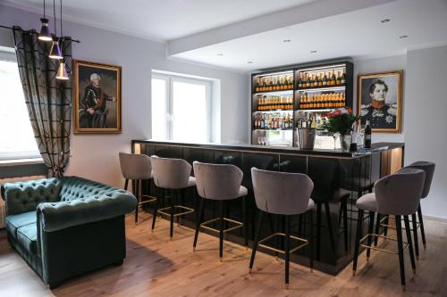 a bar with a green couch and chairs at Hotel Waldeslust in Kurort Altenberg