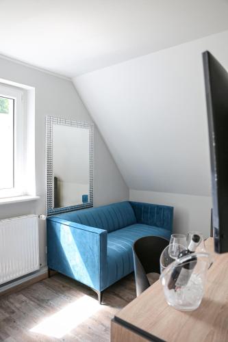 a living room with a blue couch and a mirror at Hotel Waldeslust in Kurort Altenberg