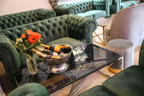 a glass table with a bottle of wine and flowers on it at Hotel Waldeslust in Kurort Altenberg